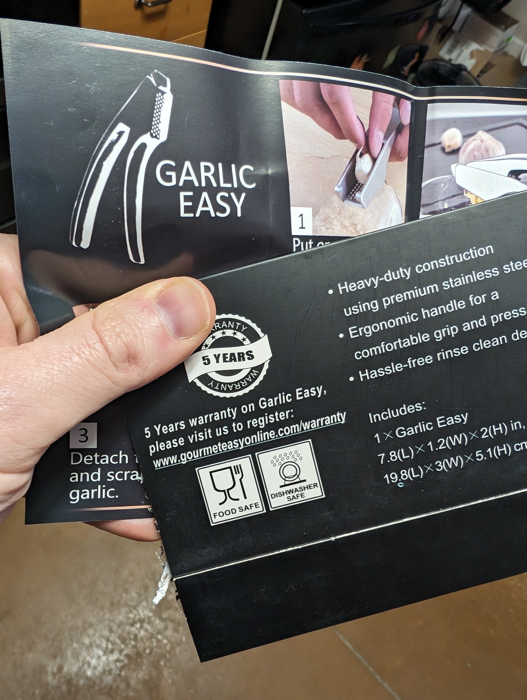 Picture of me holding the box that my Garlic Easy garlic press came in. Of note is the heavy duty construction, ergonomic handle, hassle free rinse cleaning, a five year warranty, dishwasher safe...and it's food safe.