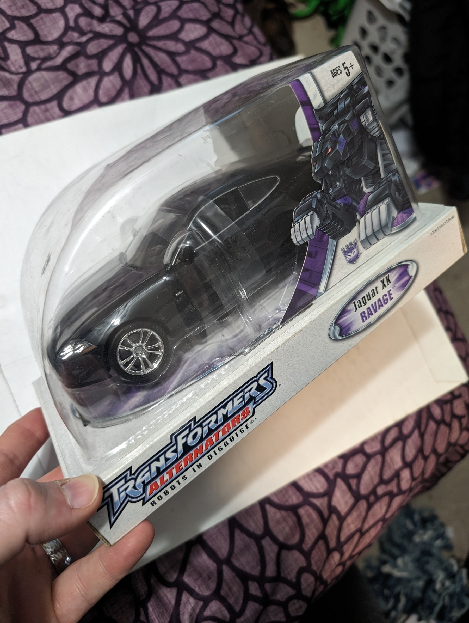 Photo of the Transformers Alternators model Ravage. A Jaguar sports luxury vehicle that changes into a killer black cat, or jaguar if you will. In an unopened box.
