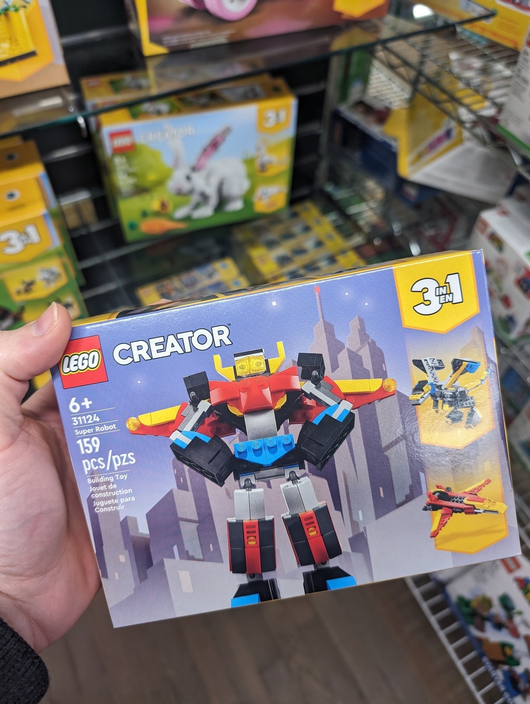 Photo of the "Super Robot" LEGO set, number 31124. Features a very cool looking robot with fists posed on hips and wings extended on its back.