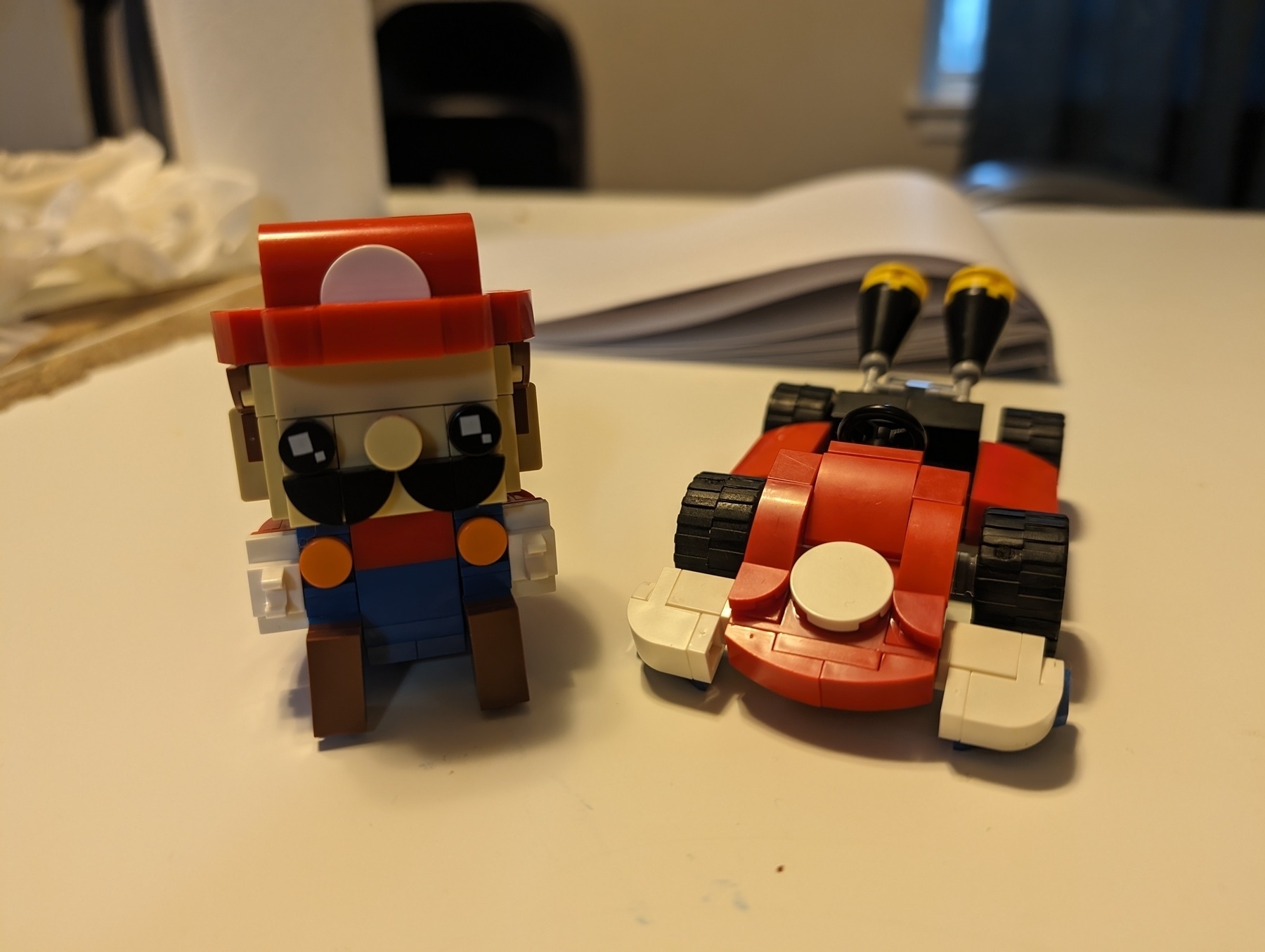 Photo of a figure built out of a brick building system, in the style of a popular character that can sit in a go cart. Any resemblance to any known character is purely coincidental.